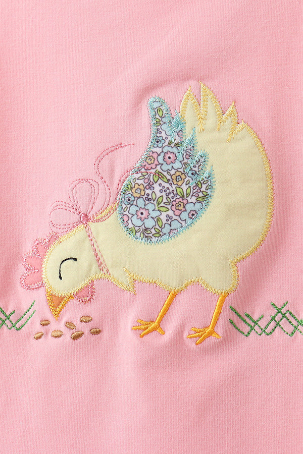 Pink baby top with cream chicken applique and a floral blue wing on soft fabric.