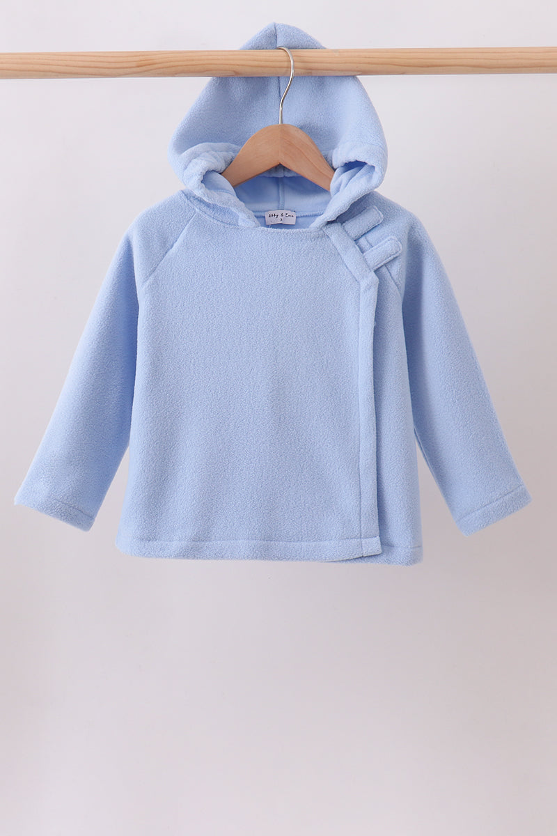 Light blue toddler fleece hoodie with side wrap closure and hook fasteners hanging on a wooden hanger.