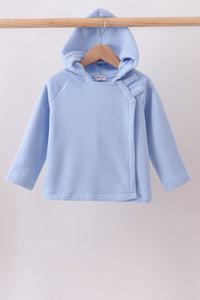 Light blue toddler fleece hoodie with side wrap closure and hook fasteners hanging on a wooden hanger.