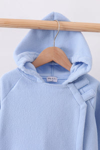 Light blue toddler fleece hooded coat with structured bow detail on shoulder, hanging on wooden hanger.