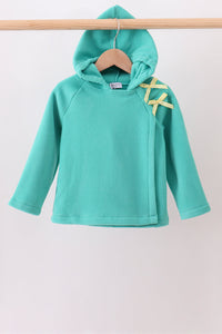 A turquoise long-sleeve hooded sweatshirt hanging on a wooden hanger from a wooden clothes rack, featuring yellow ribbon accents on the shoulder.