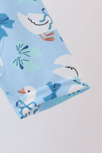 Light blue dress fabric featuring white goose prints with blue bows and playful ruffle details for a whimsical, elegant look.