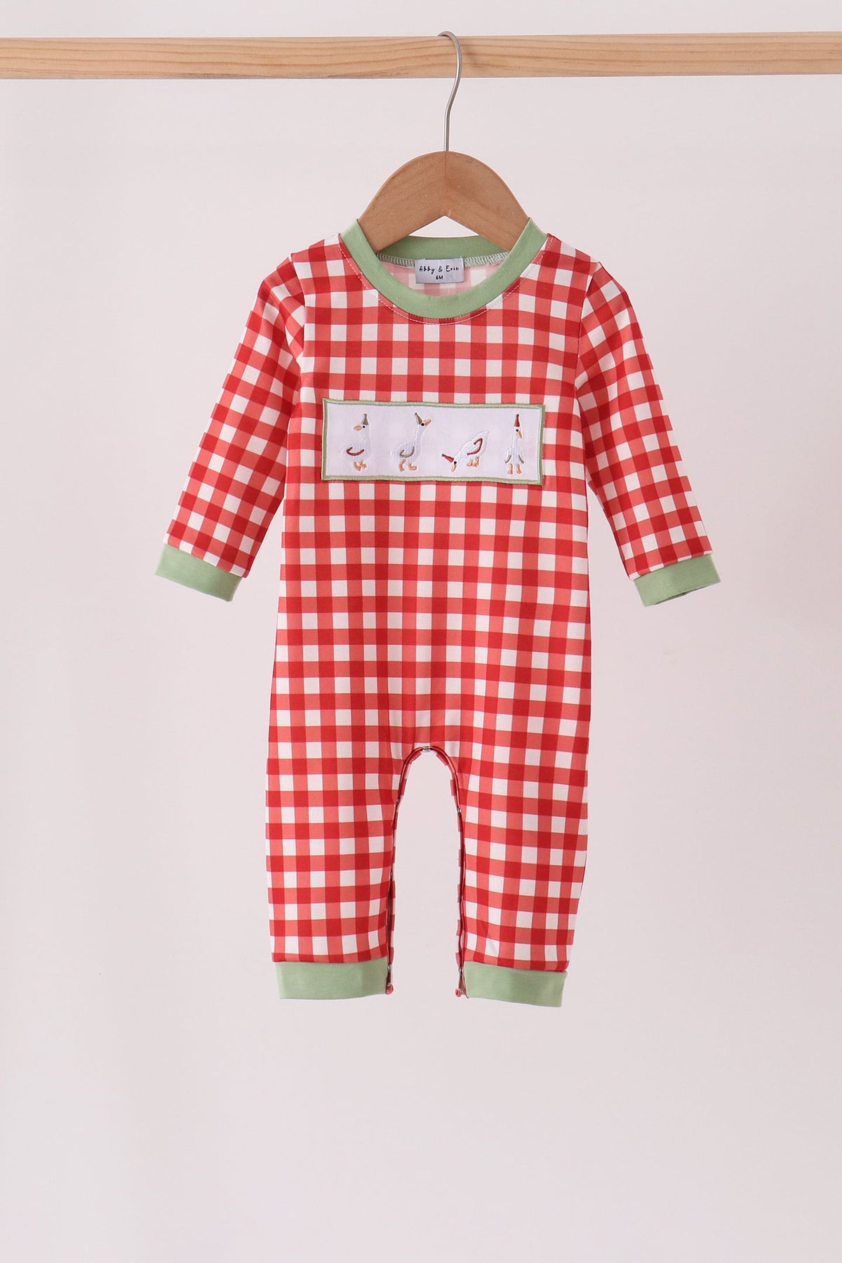Red gingham baby romper with green trim and embroidered geese patch on the chest.