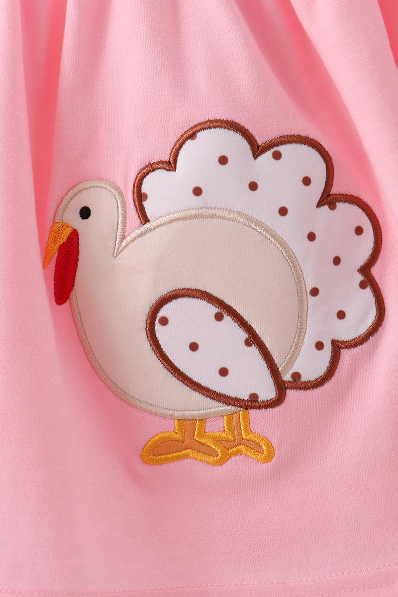 Pink turkey applique with polka dot tail on soft fabric, perfect for seasonal children's outfits.