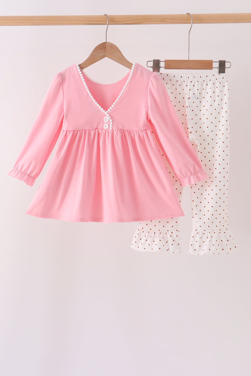 Pink girls set with long-sleeve V-neck top featuring white pom pom trim and white polka dot pants with ruffled legs.