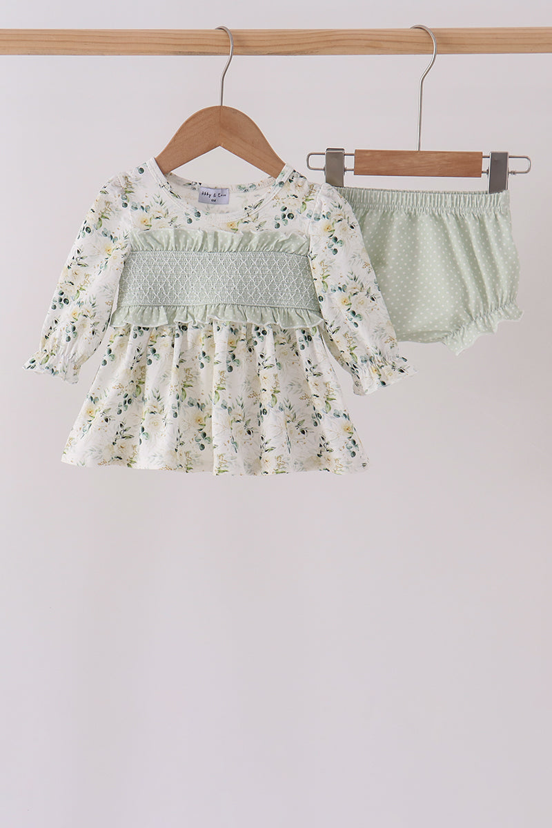 Sage floral smocked ruffle bloomer set featuring a long-sleeve top with delicate green florals, intricate bodice smocking, and playful ruffle detailing on the matching bloomers.