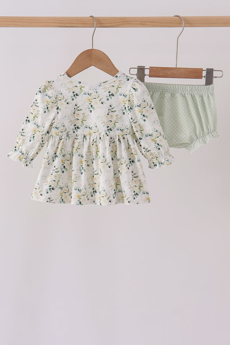 Sage floral smocked ruffle bloomer set with delicate florals, vintage-inspired top, and polka dot ruffled shorts on wooden hanger.