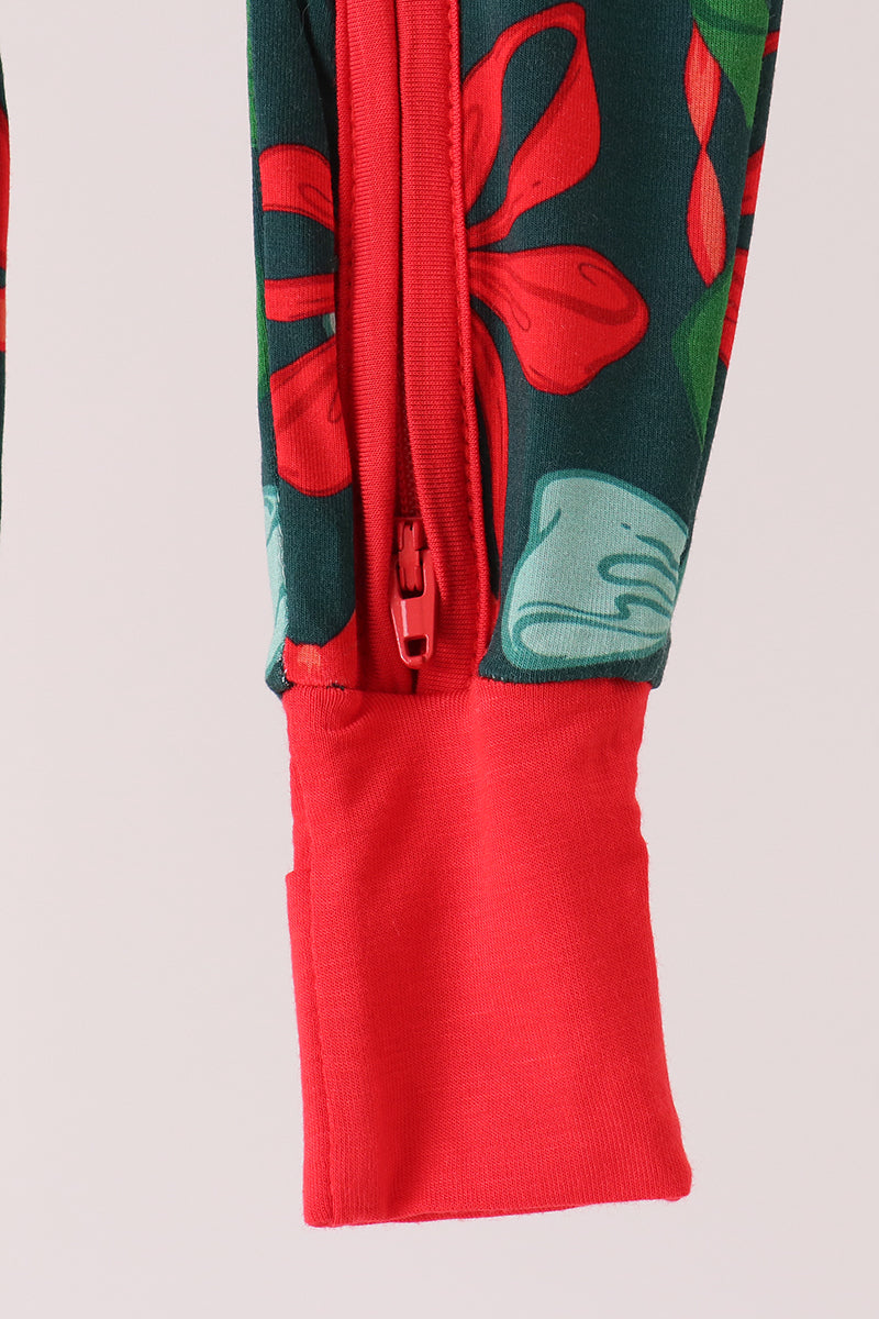 Close-up of a sleeve or garment cuff with a red zipper, red solid cuff, and a dark green floral print with red and light blue flowers.