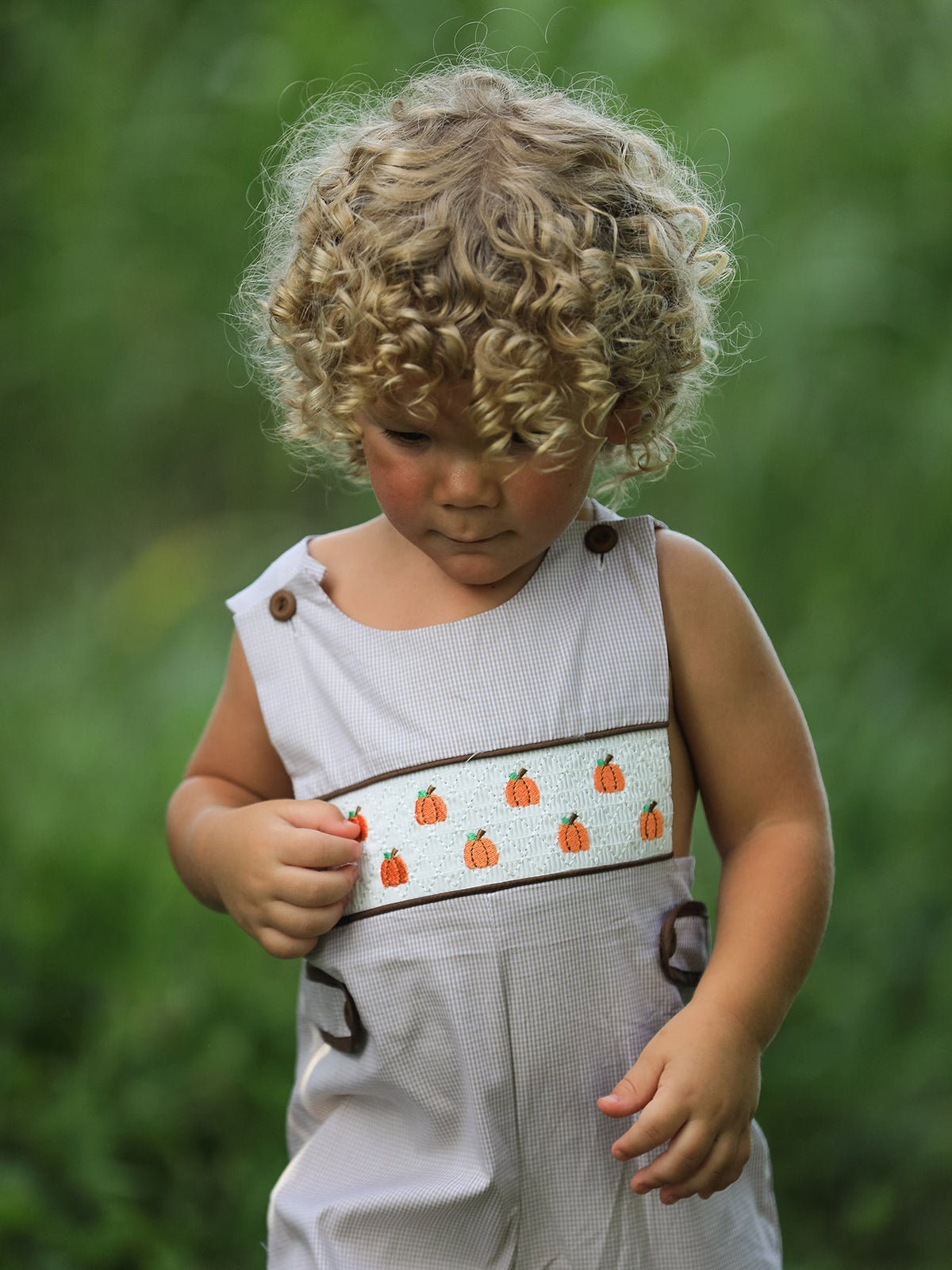 Fall Halloween & Thanksgiving Pumpkin Smock Embroidered Boys Romper with pumpkin embroidery on gray check fabric.
