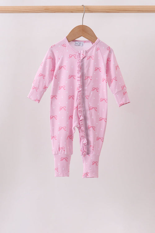Pink bow print baby romper with ruffled zipper, hanging on wooden hanger. Soft pink one-piece with playful bow pattern for infants.