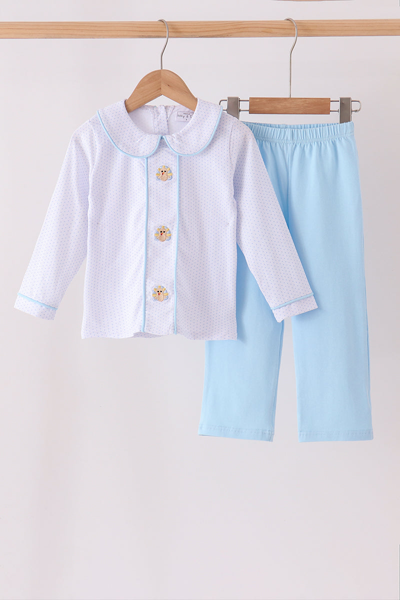 A two-piece baby clothing set hanging on wooden hangers against a plain light background. The set includes a white long-sleeve cardigan with a light blue collar and trim, featuring three decorative wooden buttons, and light blue pants.