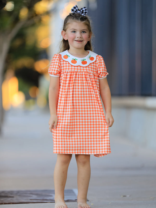 Girl wearing orange gingham puff sleeve dress with pumpkin embroidered scalloped collar for fall.