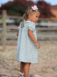 Little girl in a green plaid dress with a pumpkin applique, perfect for fall, Halloween and Thanksgiving.
