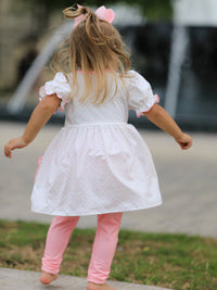 A girl wearing the Back To School Girls' Apple Applique Set with Pockets, enjoying her school day in style.