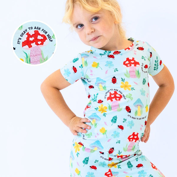 The Second-Skin 2-Piece Short Sleeve Pajama worn by a child with blue print featuring 'It's Okay to Ask for Help' text