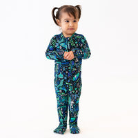 Child wearing The Second-Skin Convertible Romper in Blue, with tropical-print pattern and front zipper.