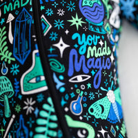Close-up of The Second-Skin Footie Mystic Mama Blue fabric with teal & cyan doodles and stars.