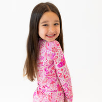Smiling girl in pink Mystic Mama Second-Skin 2-Piece Long Sleeve Pajama.