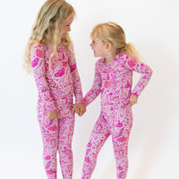 Two girls in pink Second-Skin 2-Piece Long Sleeve Pajamas (Mystic Mama) with You Made Magic print.