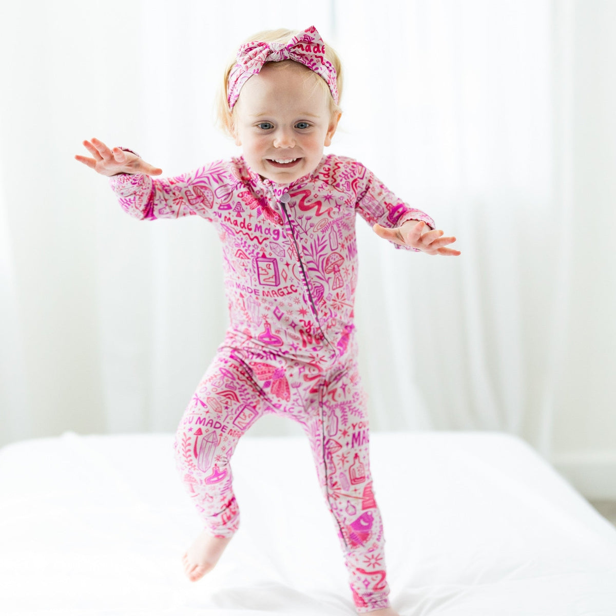 Toddler wearing pink printed zippered romper from The Second-Skin Convertible Romper by Pink Mystic Mama.