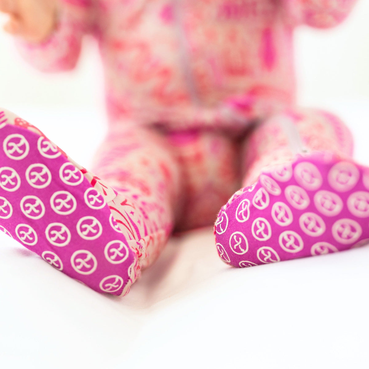 The Second-Skin Bamboo Zippered Footie | Mystic Mama artistically presented among baby accessories, highlighting its practical features.