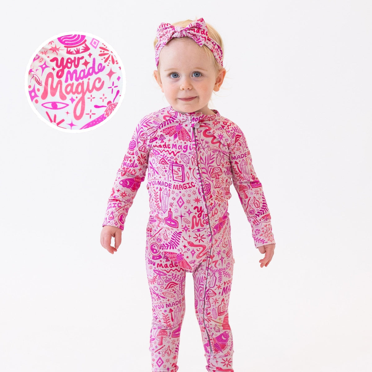 Toddler wearing The Second-Skin Convertible Romper in pink Mystic Mama with bow headband.