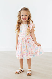 Girl in Off to the Circus Flutter Sleeve Twirl Dress, pink circus-print with flutter sleeves.