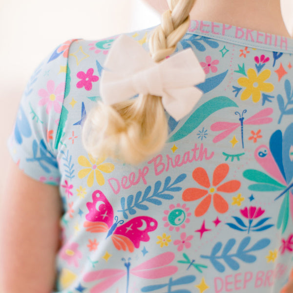 Light blue The Second-Skin 2-Piece Short Sleeve Pajama set by Om Baby with colorful prints and a white bow.