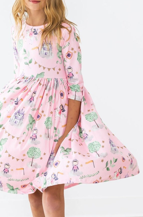 Once Upon a Time 3/4 Sleeve Pocket Twirl Dress by Mila & Rose, featuring a playful design with castles and whimsical characters, twirling gracefully as a young girl enjoys her magical moment.