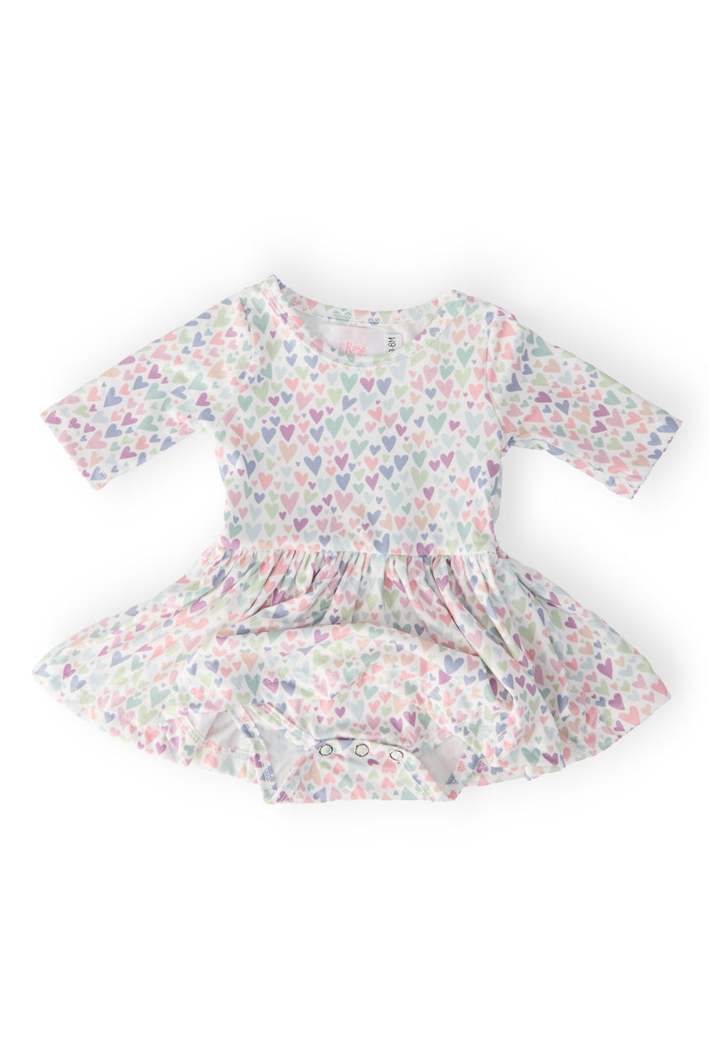 One in a Million 3/4 Sleeve Twirl Bodysuit by Mila & Rose® displayed flat, featuring a playful heart pattern and convenient snap closure for easy dressing.