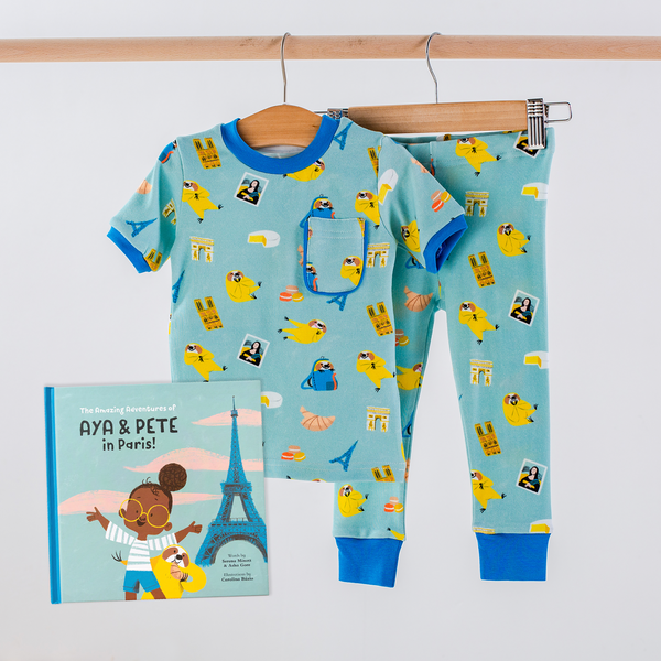 Aya & Pete in Paris Organic Cotton Kids Pajamas & Book Set: turquoise PJs with Paris landmarks and birds.