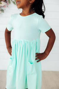 Pastel green short-sleeve pocket twirl dress for girls with side pockets.