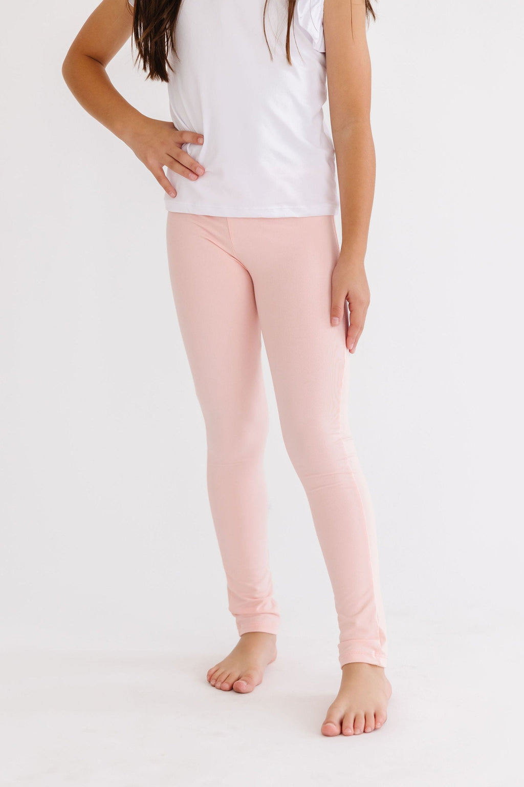 Adorable Peach Leggings by Mila & Rose showcasing a young model posing with a playful hand on her hip, perfect for a stylish and comfortable day.