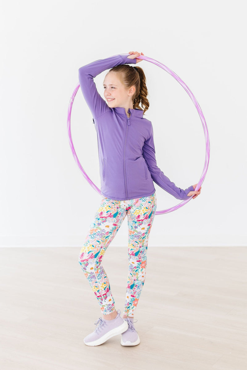 A girl playfully posing with a hula hoop wearing "Petal Power" Girls Active Leggings, radiating joy and energy.