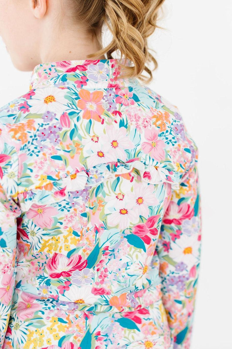 Close-up view of the back of the Petal Power Full-Zip Ruffle Active Jacket, highlighting its charming ruffle detailing amidst a colorful floral pattern.