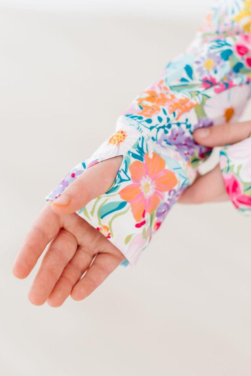 Detail of the sleeve of the Petal Power Full-Zip Ruffle Active Jacket featuring a thumbhole design, perfect for keeping her warm while adding a playful element.
