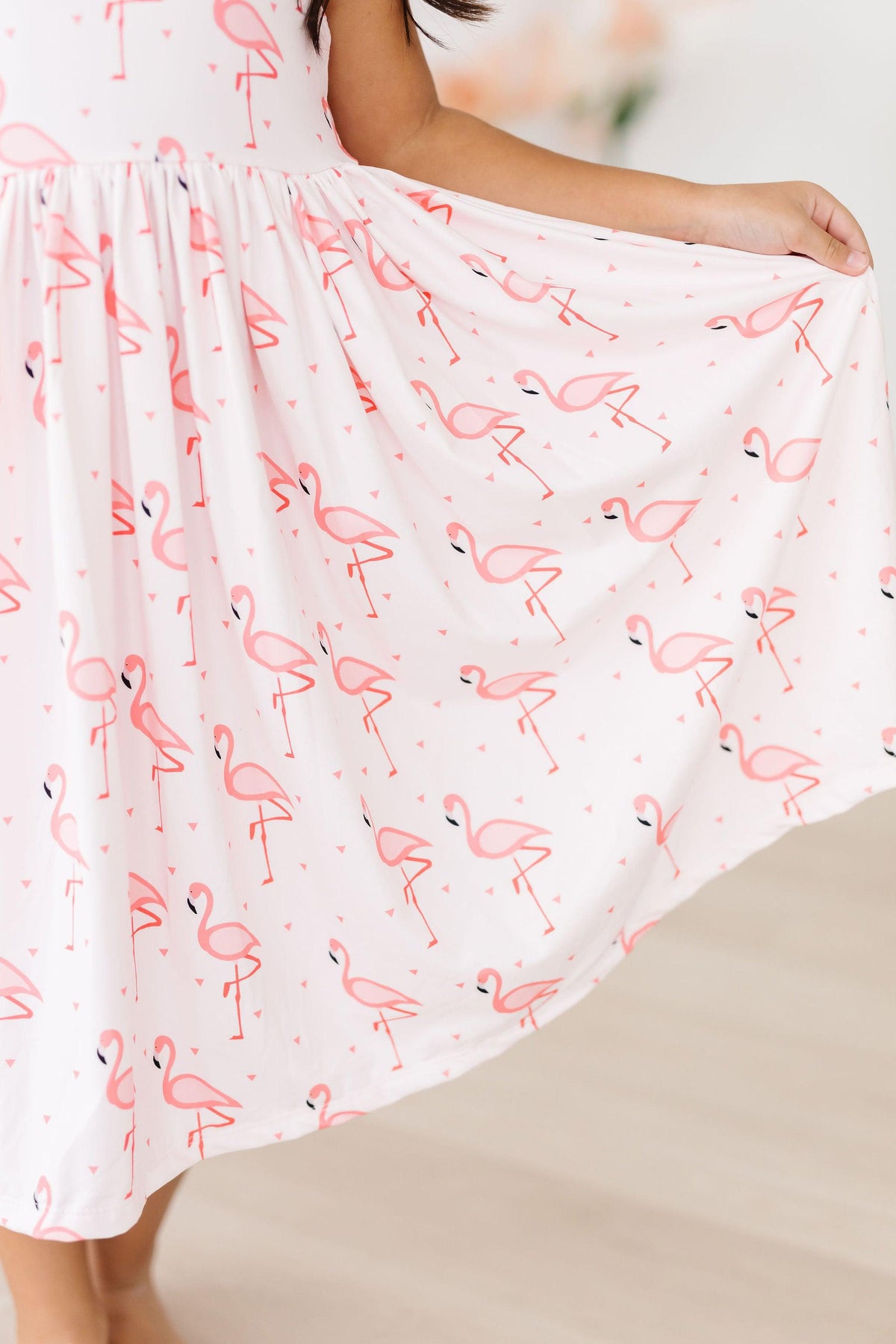 Playful scene featuring the Pink Paradise Flamingo Tank Girls Twirl Dress, capturing the essence of fun and movement for little fashionistas.