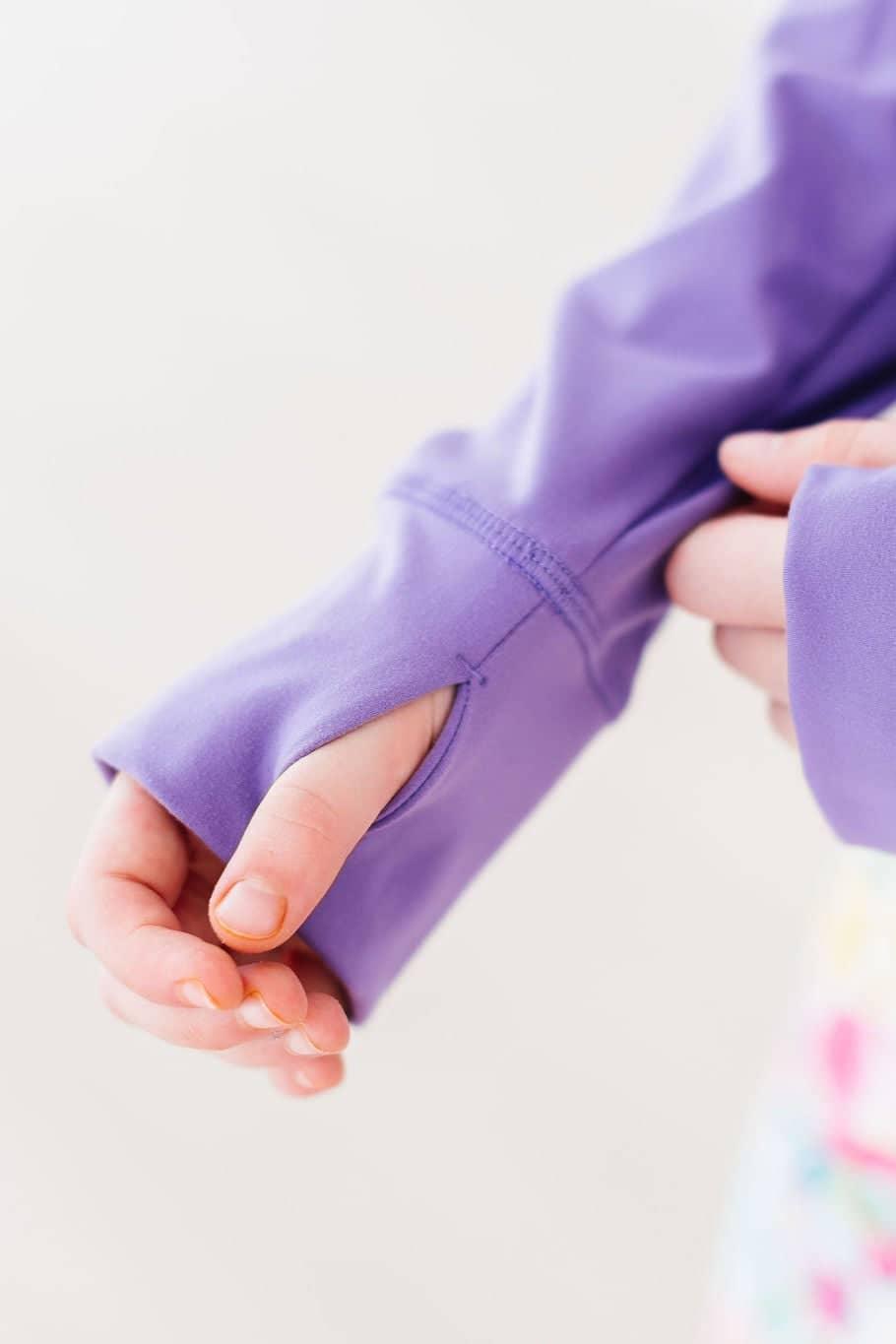Close-up of child’s lavender active jacket sleeve with thumb hole detail by Mila & Rose