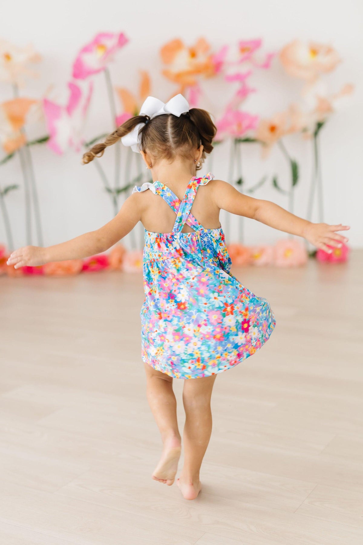 Preppy Floral Ruffle Cross Back Dress on a girl, colorful floral print, criss-cross back and ruffle straps.