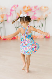 Preppy Floral Ruffle Cross Back Dress on a girl, colorful floral print, criss-cross back and ruffle straps.
