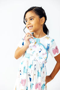 Smiling child wearing a white puppy print belt bag with blue trim as a crossbody accessory for hands-free fun.
