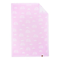 Lilac pink baby blanket with white rainbow jacquard pattern, folded corner showing white reverse and brown brand tag