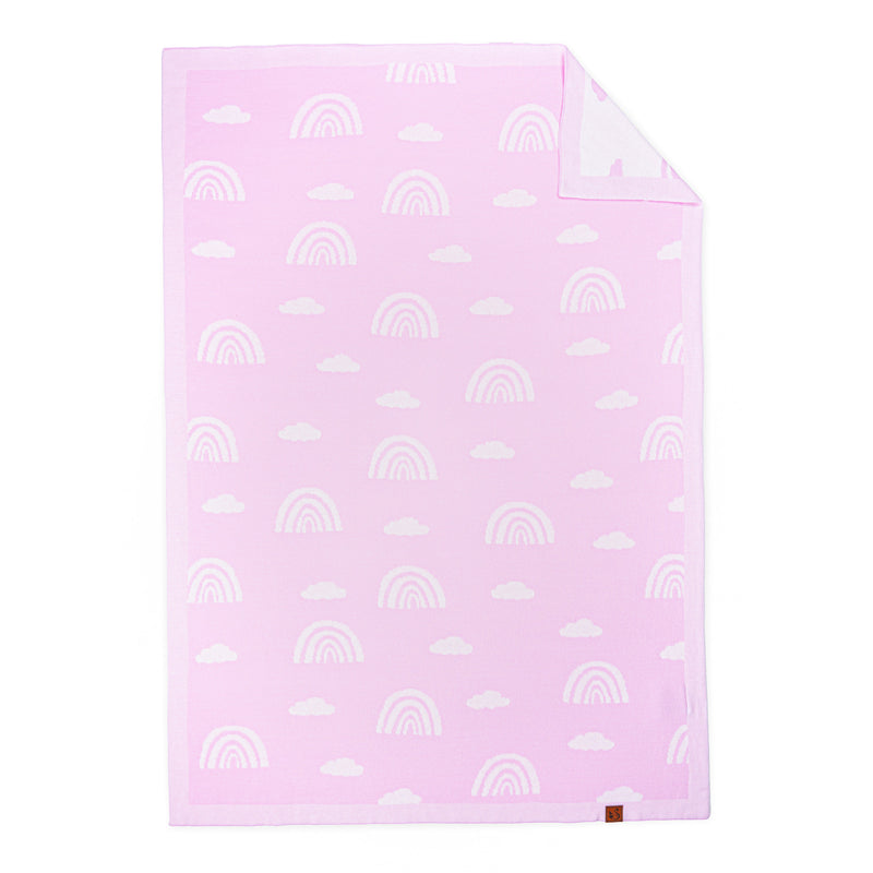Lilac pink baby blanket with white rainbow jacquard pattern, folded corner showing white reverse and brown brand tag