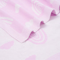 Close-up of ribbed border edge on light lilac cotton blanket highlighting soft wavy fold and fine knit texture