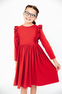 Girl modeling red long sleeve ruffle twirl dress with comfortable fit, scoop back, and easy-wash fabric for school or play.