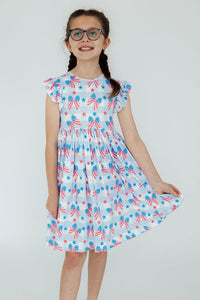 Girl wearing Red, White & Bows Flutter Sleeve Twirl Dress with patriotic stars and bows.