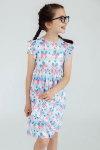 Girl wearing Red, White & Bows Flutter Sleeve Twirl Dress in light blue with patriotic bows and stars.