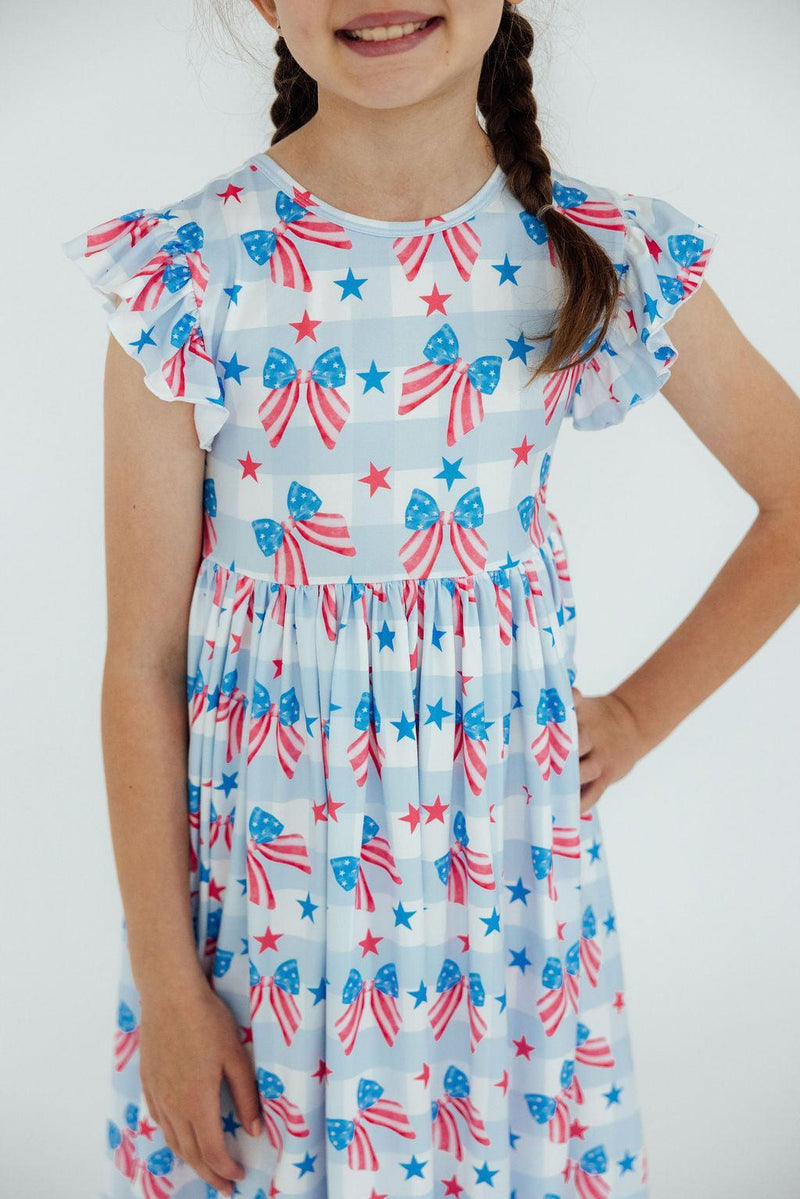 Red, White & Bows Flutter Sleeve Twirl Dress with bow-and-star print on a girl.