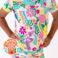 The Second-Skin 2-Piece Short Sleeve Pajama in Rainbow Daisy Babe floral print worn by a parent.
