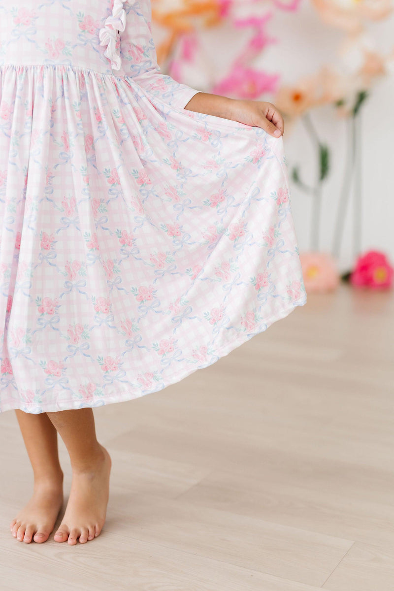 Close-up view of the Ribbons & Roses 3/4 Sleeve Ruffle Twirl Dress, highlighting the twirly skirt and soft floral design, ideal for little fashionistas.